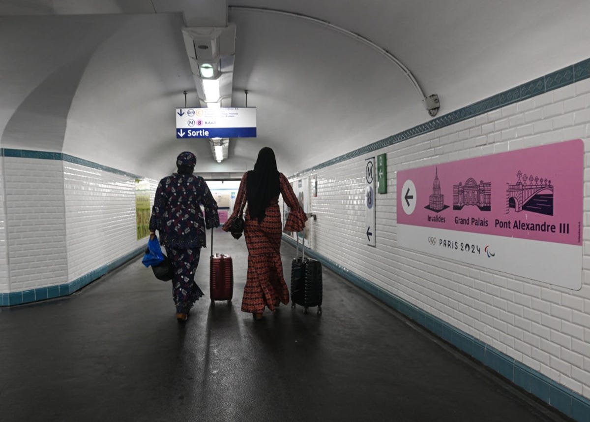 Two people walk in a subway station