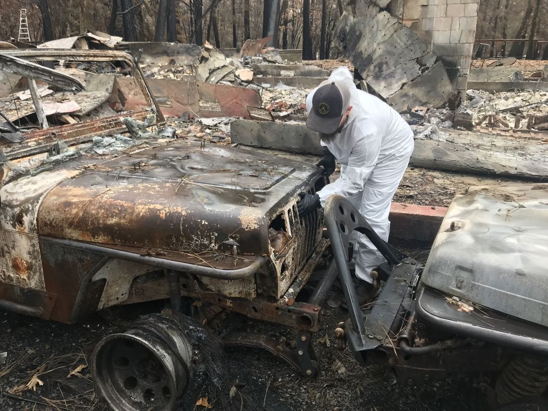 Michael Daneau examining damage to the couple's home that was destroyed by the Camp Fire in 2018.