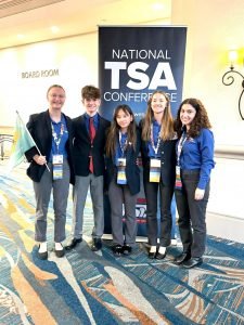 A group of Delaware TSA students stand smiling at the camera.