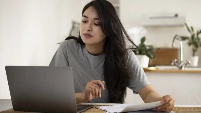 Beautiful Mongolian woman taking care of her finances at home stock photo