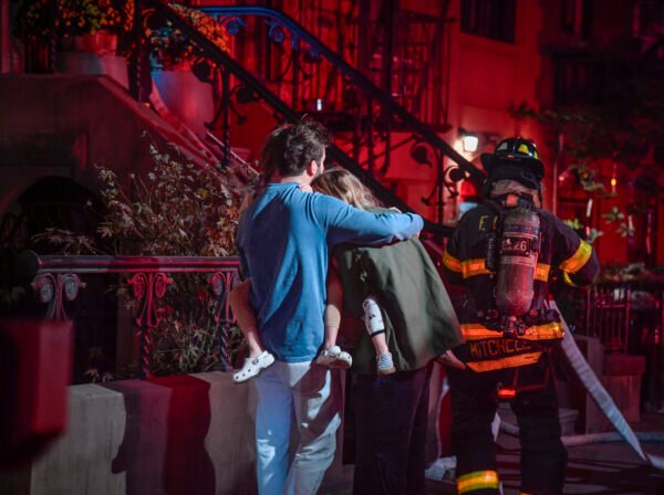 Tenants huddle with their kids outside as firefighters extinguish the flames. Photo courtesy of Marc Hermann