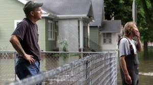 Tom Melsh (left) and Rick Hobson stare at the floodwaters rushing down J Street in southwest Cedar Rapids on June 13, 2008. The flood covered 10 square miles in the city’s center. Almost 6,000 homes were flooded. (The Gazette)