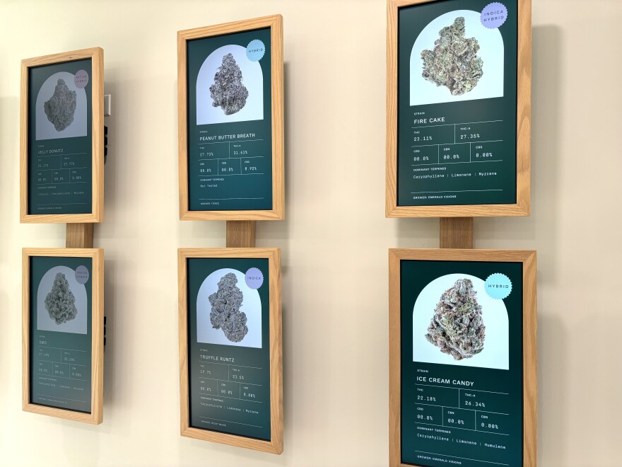 Signs on a wall showing photos of cannabis flower and their attributes