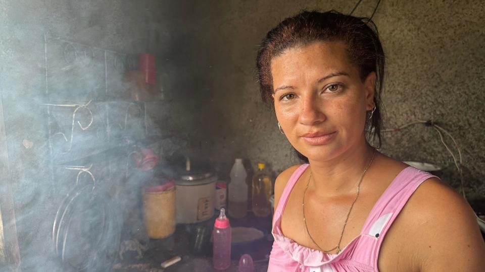 Woman in pink dress looks into camera