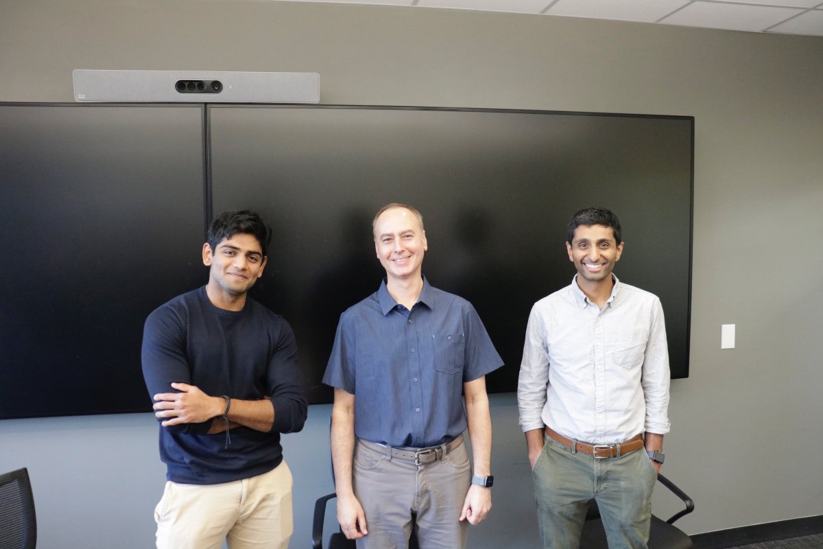 Rohan Parekh, energy fair organizer, stands next to panel speakers Scott Zafiropoulo, and Tarun Narayan