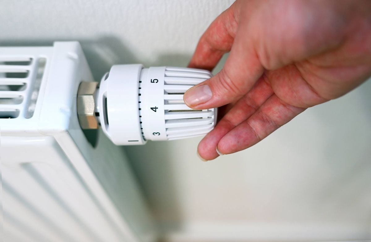 Person is adjusting temperature on radiator
