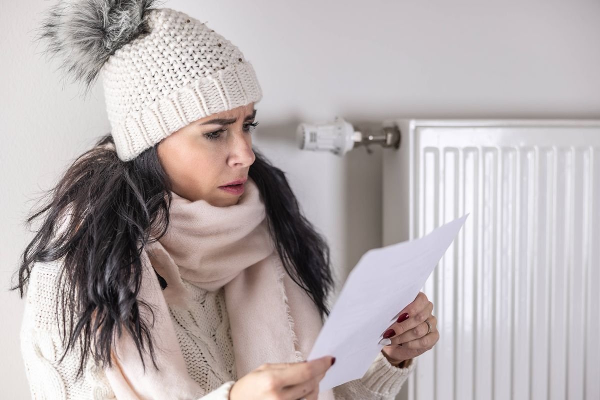 Yound woman is shocked from the rising energy costs and the bill she received for heat and electricity for her household.