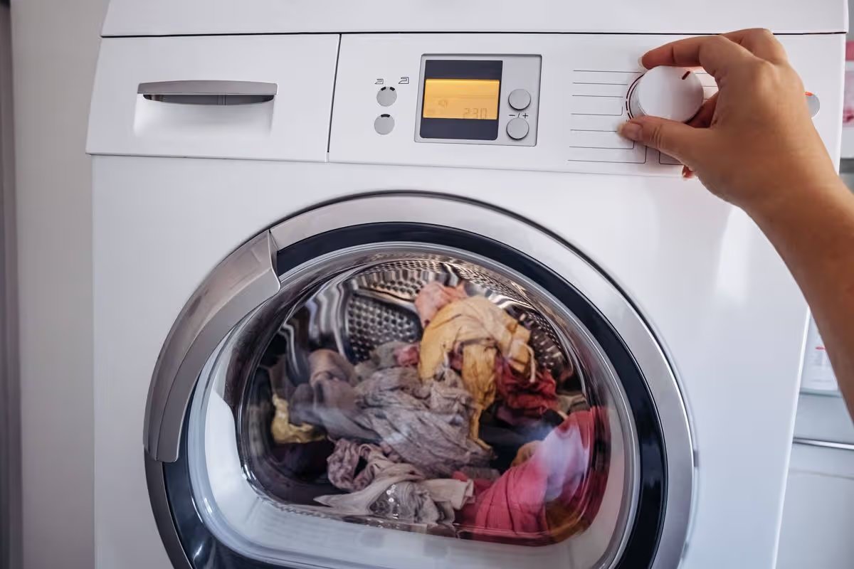 Laundry inside tumble dryer with control panel visible