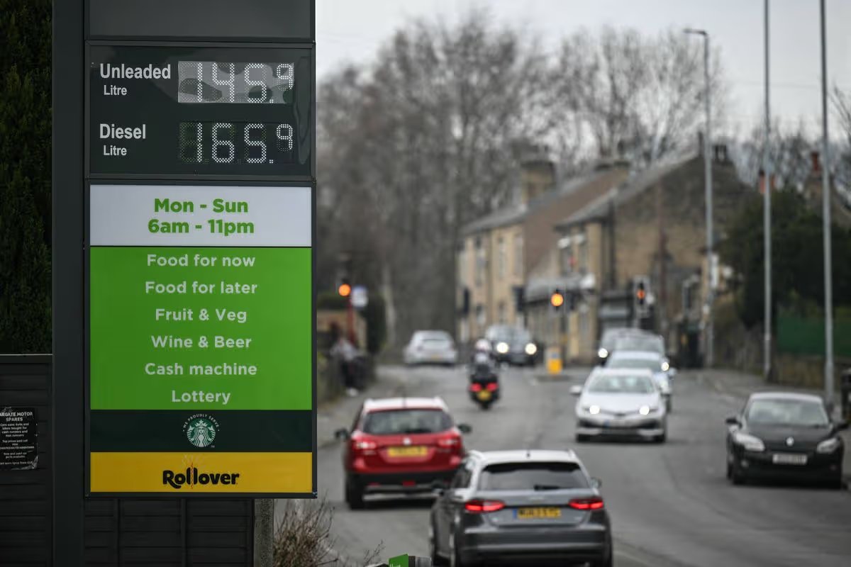 A signboard (L) showing prices for petrol and diesel is pictured at a petrol service station in Milnsbridge, suburban Huddersfield, northern England on March 19, 2026. Britain's energy minister warned petrol retailers on March 13 that the government would not tolerate "unfair practices" amid a row over rising fuel prices sparked by the Middle East war. European gas prices soared as much as 35 percent on March 19 as fresh strikes hit energy infrastructure in the Middle East, including Qatar's main gas facility. (Photo by Oli SCARFF / AFP via Getty Images)