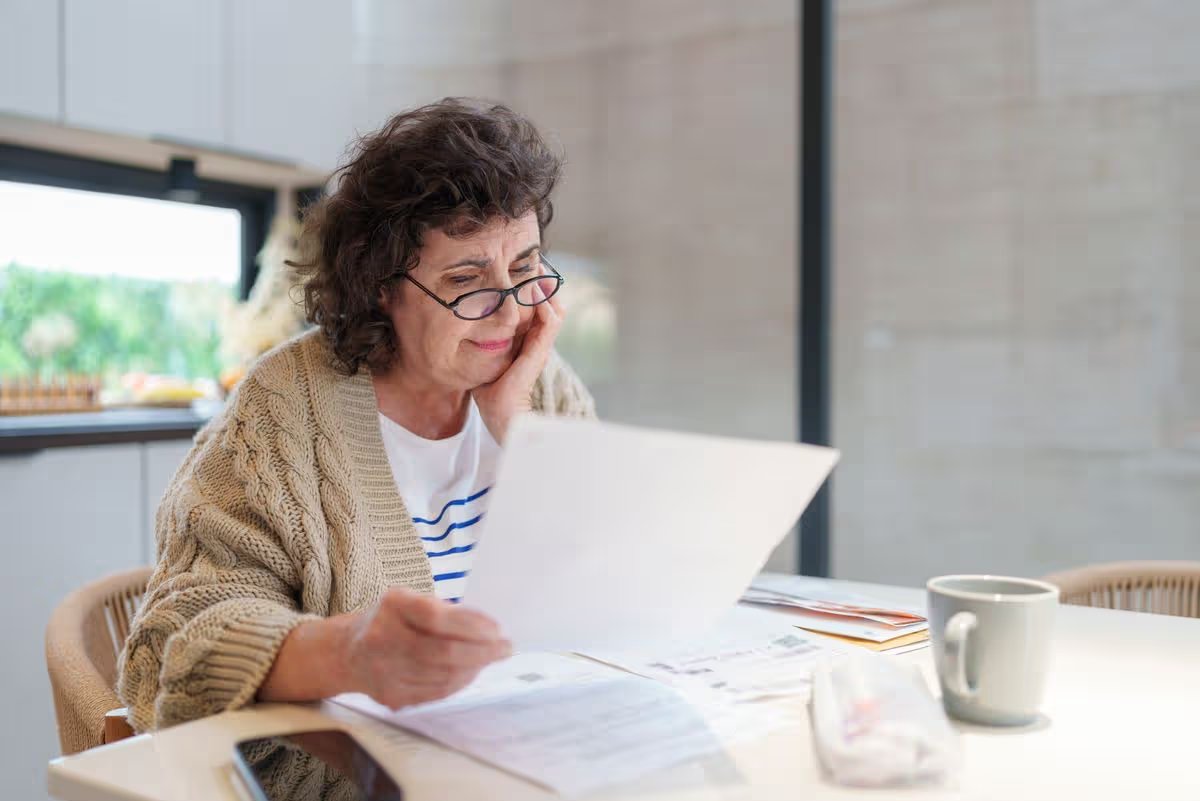 Stressed and Worried Senior Woman Calculating Domestic E