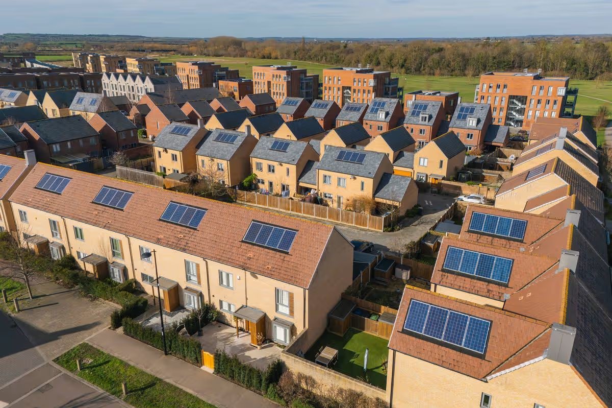 An aerial/drone view of a new housing development in the UK. The roofs have solar panels installed