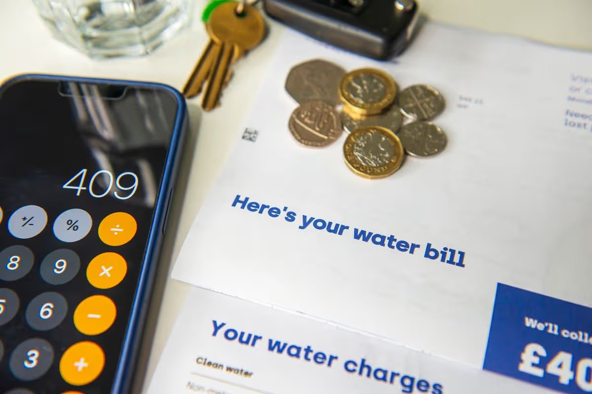 Water bill next to a calculator and coins