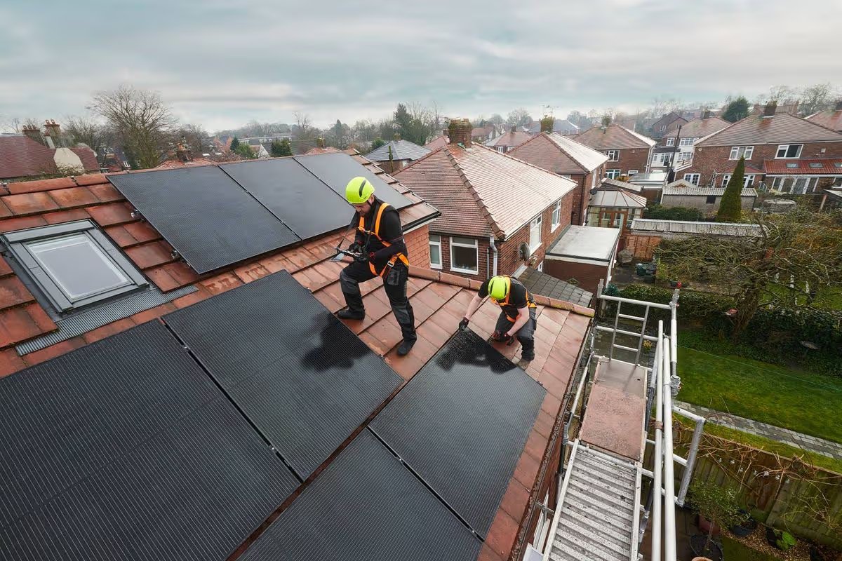 A team install solar panels on a house