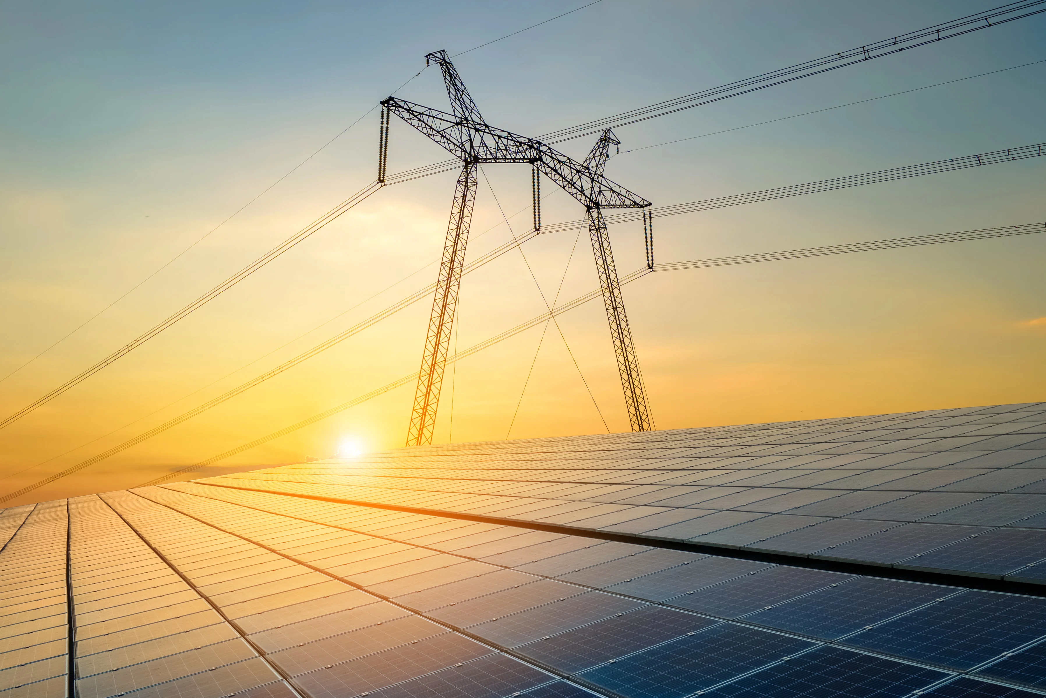 A solar panel with a transmission tower in the background.
