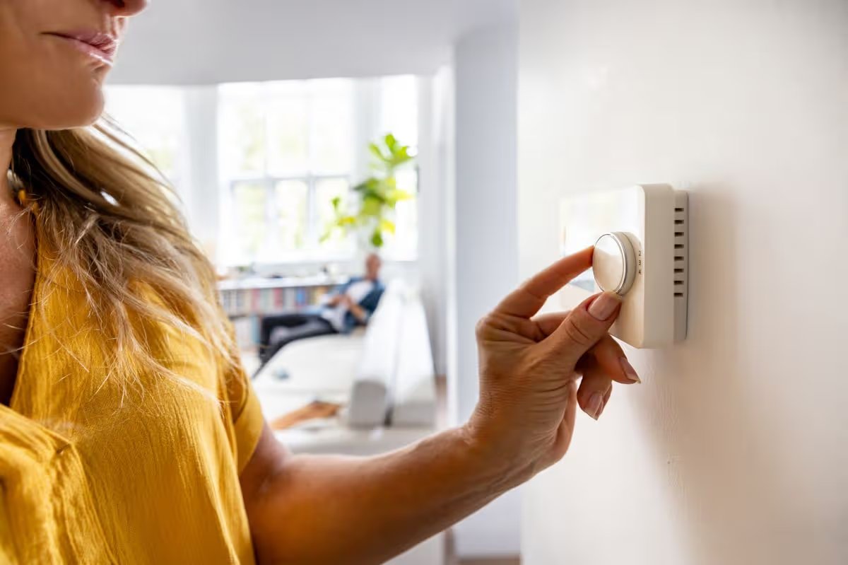Close-up on a woman adjusting the temperature of her house with a dimmer