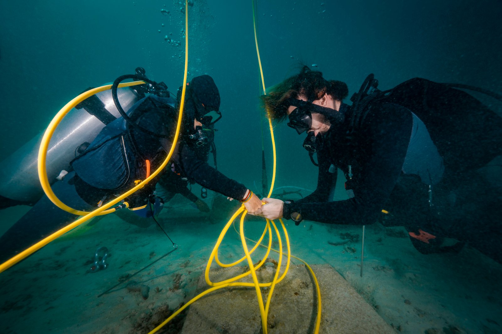 Scuba Divers Installing undersea cables for research purposes