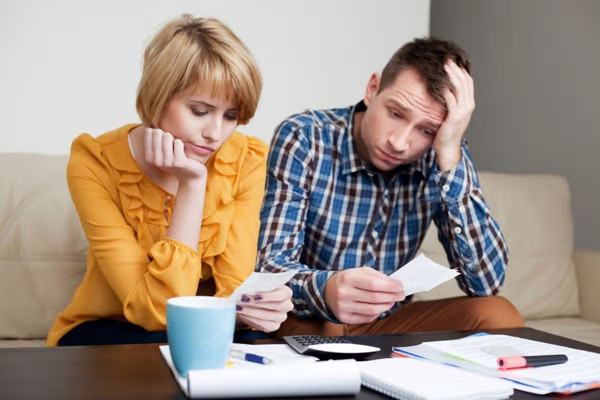Getty generic. Sad, depressed young couple paying bills.
